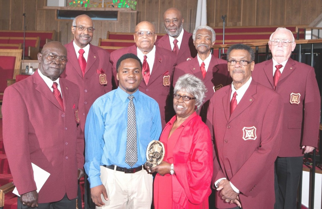 SHAD Club President Anthony Bell (back row-fourth from left) presented the 2013 winning plaque and cash award to DeShawn Redden (center front), whose stated career goal  is to be a teacher and to be active in the community. He has already demonstrated community support by helping to mentor young disadvantaged children. DeShawn was joined by Mrs. Faye Jackson, (center) wife of Mr. Samuel Jackson in whose memory the plaque is given.  They are surrounded by other members of SHAD Club #62 including Vice President Bobby Magby 1, who stands beside Mrs. Jackson on the right.