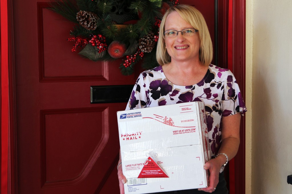 Bringing Holiday Cheer to Others Giving Overseas.  Loma Linda University Health employee Karen Westphal holds a package that she and her husband filled with Christmas goodies for their adopted missionary family. 